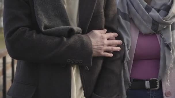 Närbild av manliga kaukasiska händer som tar kvinnohandflatan. Vuxna par som promenerar utomhus. Romans, kärlek, äktenskap, fritid. — Stockvideo