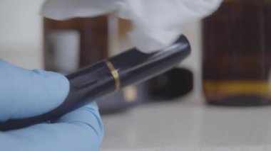 Maskara 'yı dezenfektanla temizleyen mavi koruyucu eldivenli eller. Koronavirüs karantinası sırasında makyaj yapan kadın. Güzellik, sağlık, Covid-19 tecrit.