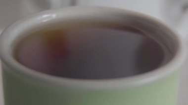 Şekerin aşırı yakın çekimi bir fincan siyah çaya düşer. Bilinmeyen kişi içeceğe kristal organik glikoz ekliyor. Günaydın, yaşam tarzı, aromatik içecek..