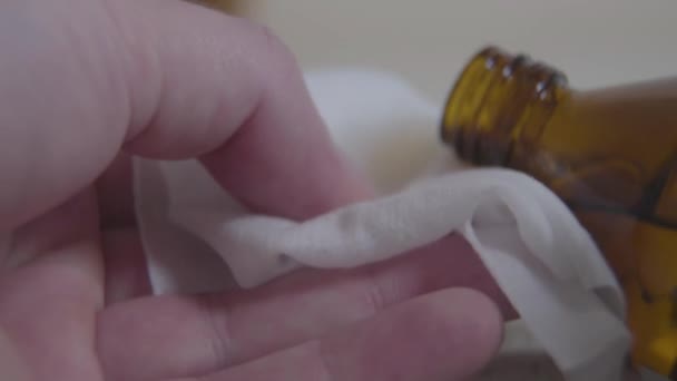 Main blanche versant un désinfectant liquide sur la serviette. Gros plan d'un jeune homme inconnu se préparant à désinfecter son smartphone avec du désinfectant. Covid-19, hygiène, isolement du coronavirus .