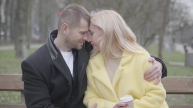 Evli çiftleri sevip burunlarını sürterek parkta bankta oturuyormuş gibi konuşuyorlar. Yetişkin beyaz erkek ve kadın birlikte dışarıda vakit geçiriyorlar. Birlik, aşk, romantizm, yaşam tarzı.