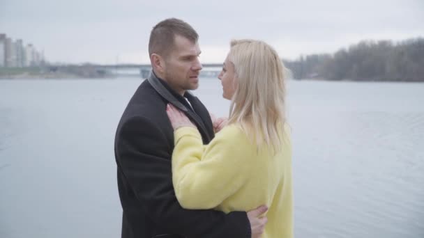 Feliz morena caucásica hombre bailando y hablando con rubia hermosa mujer al aire libre. Amante marido disfrutando de tiempo con su esposa en la orilla del río. Amor eterno, romance, unión, unidad. estilo de vida . — Vídeos de Stock