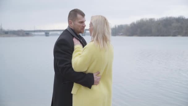 Selvsikker hvid mand spinning blond kvinde i sensuel dans på flodbredden. Midterste skud af lykkelige voksne ægtepar dating udendørs. Romantik, kærlighed, samvær, enhed, sammenhold . – Stock-video