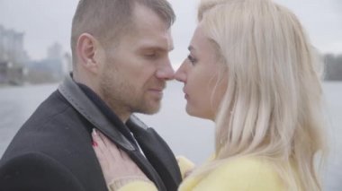 Dans eden ve burunlarını ovuşturan sevgili çiftlerin yakın çekimi. Beyaz adam ve kadın birbirlerine sevgiyle bakıyorlar. Nehir kıyısında flört eden evli bir çift. Sonsuz aşk, birlik, bağlılık, romantizm.