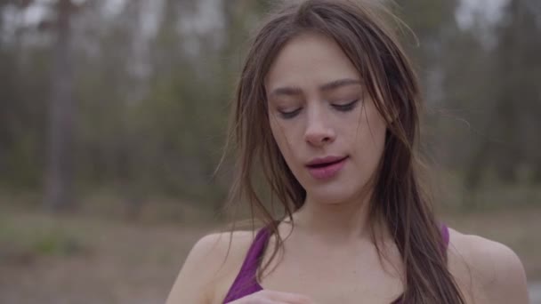 Primer plano de la joven deportista hermosa beber agua en el parque y salir. Retrato de chica morena confiada entrenando al aire libre en la mañana. Aficion, estilo de vida, deporte, fitness . — Vídeos de Stock