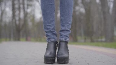 Kamera, dar, beyaz bir kadının koruyucu maske takarak park alanında dikilirken görüntüsünü kaydediyordu. Esmer kızın Covid-19 karantinasında dışarıda geçirdiği bir portre..
