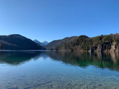 Neuschwanstein kalesinin yakınlarındaki güneşli bir günde Alpsee Gölü 'nün göz kamaştırıcı manzarası. Schwangau, Bavyera, Almanya