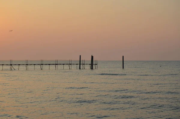 Beautiful coastline of the Adriatic Sea. Sunrise on the beach of Lido di Jesolo. Piers in the sea