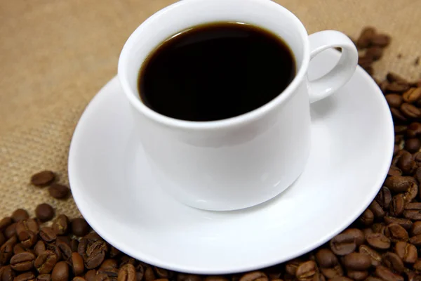 Café caliente con un fondo de granos de café —  Fotos de Stock