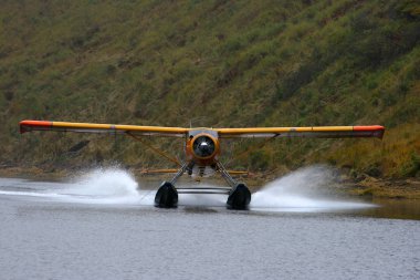 Alaska'da bir göl üzerinde açılış deniz uçağı