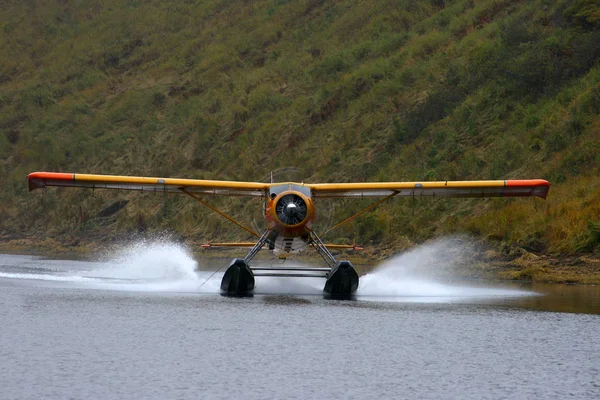 Wasserflugzeug landet auf einem See in Alaska lizenzfreie Stockfotos