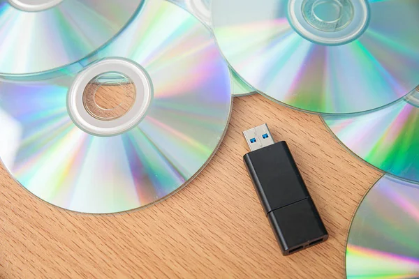 USB flash sürücüler ve yığın CD ahşap arka plan üzerinde izole etmek.