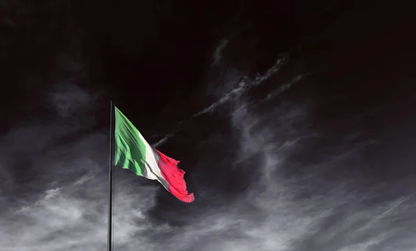 Bandiera italiana in un cielo buio, l'emergenza non spegne i colori della bandiera — Foto Stock