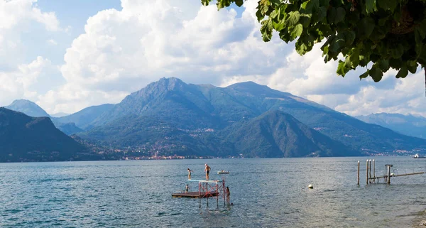 Bellagio, Itálie - 13. srpna 2013: skupina lidí se potápí z trampolíny v jezeře Como v Bellagiu — Stock fotografie