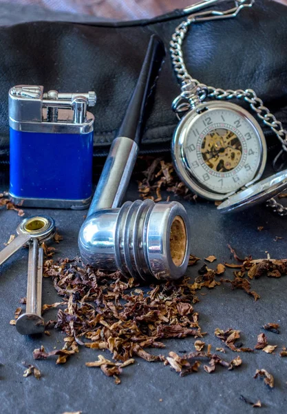 Aristicob pipe still life with pipe tools, pocket watch, and loose tobacco
