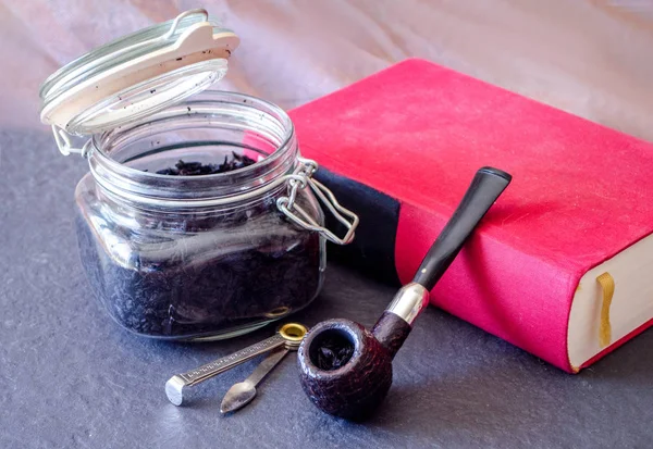 prince pipe and tobacco still life with jar of loose tobacco, czech tool and red novel
