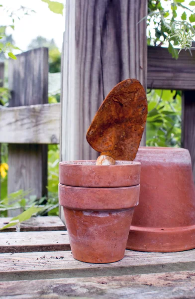 Pots en argile avec pelle rouillée sur un banc de mise en pot — Photo