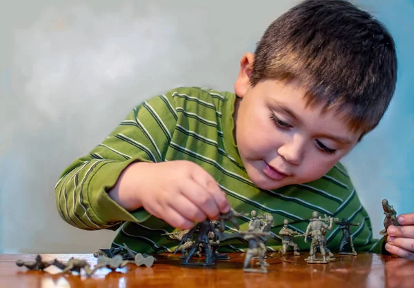 Mladý chlapec s plastovými figurkami hraje válku — Stock fotografie