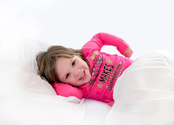 Schläfriges kleines Mädchen in einem weißen Schlafzimmer — Stockfoto