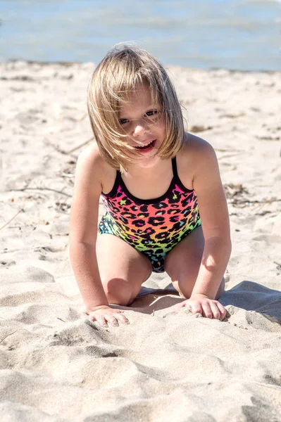 Little girl plays in the sand on a vacation — Stok fotoğraf