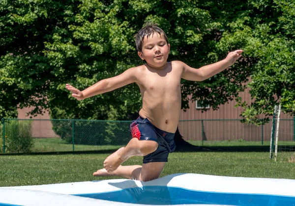 Niño Capturado Aire Mientras Salta Una Piscina Inflable Patio Trasero —  Fotos de Stock