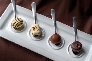Gümüş kaşıklar, bu çikolata tatma etkinliğinde çeşitli merhum çikolataları barındırır.