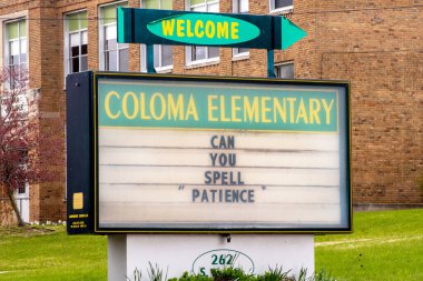 Coloma MI USA 23 Nisan 2020; Bir ilköğretim okulunun önündeki bir tabela, korona-virüs salgınının ortasında evde kaldıkları süre boyunca kendilerini evde öğretmen olarak bulan tüm velilere komik tavsiyeler veriyor.