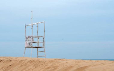 Issız bir cankurtaran durağı boş bir sahile bakıyor ve Michigan Birleşik Devletleri covid-19 salgını sırasında çapayı tutuyor.