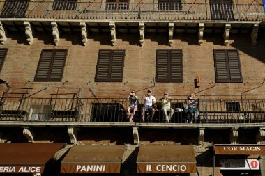 İnsanlar 25 Ekim 2019 'da İtalya' nın Siena kentindeki Piazza del Campo (Campo Meydanı) 'nda güneşli günün tadını çıkarıyorlar.