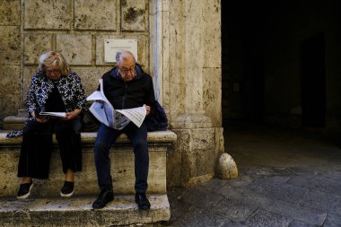 İnsanlar Siena, İtalya 'da 26 Ekim 2019' da gazete okuyor..