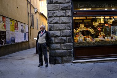 Yaşlı bir insan, 26 Ekim 2019 'da İtalya' nın Siena şehrinin tarihi merkezinde yürüyor..