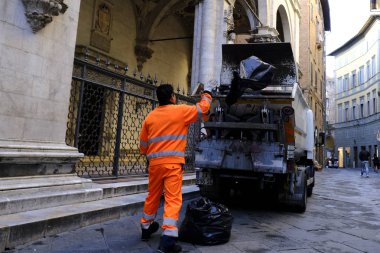 Bir belediye çalışanı, 26 Ekim 2019 'da İtalya' nın Siena kentindeki sokaklara çöp bidonları boşaltıyor.