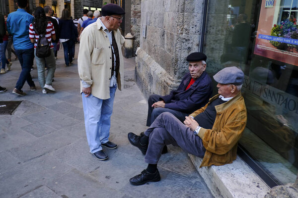 Пожилые люди сидят в мраморной ступени в историческом центре Сиены, Италия 27 октября 2019 года
.