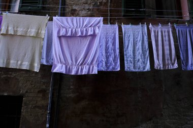 26 Ekim 2019 'da İtalya, Siena' da balkondan sarkan giysiler rüzgarda kuruyor.