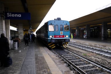 Yolcular, 28 Ekim 2019 'da İtalya' nın Siena kentindeki merkez tren istasyonuna bir banliyö treni geldikten sonra platformda yürürler.