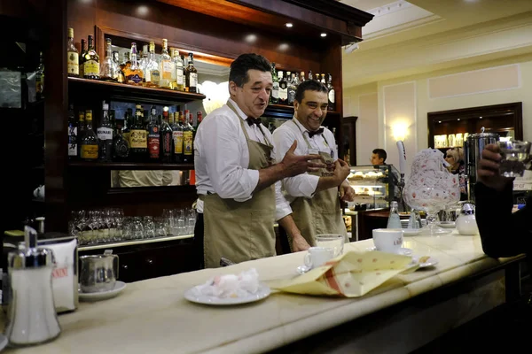 Baristas, 26 Ekim 2019 'da Siena, İtalya' da tipik bir espresso barında kahve hazırlıyor.