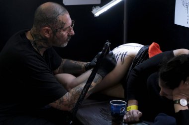 Brüksel, Belçika. 9 Kasım 2019. Uluslararası Brüksel Dövme Kongresi sırasında bir dövme sanatçısı bir kişiye dövme yaptırdı.