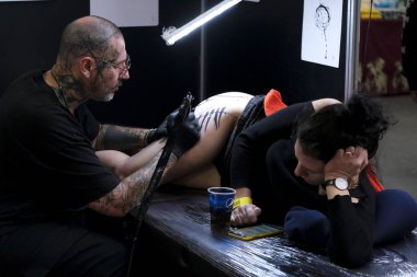 Brüksel, Belçika. 9 Kasım 2019. Uluslararası Brüksel Dövme Kongresi sırasında bir dövme sanatçısı bir kişiye dövme yaptırdı.