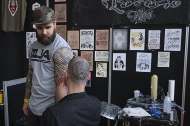 Brüksel, Belçika. 9 Kasım 2019. Uluslararası Brüksel Dövme Kongresi sırasında bir dövme sanatçısı bir kişiye dövme yaptırdı.