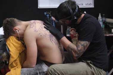 Brüksel, Belçika. 9 Kasım 2019. Uluslararası Brüksel Dövme Kongresi sırasında bir dövme sanatçısı bir kişiye dövme yaptırdı.
