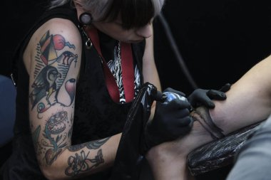 Brüksel, Belçika. 9 Kasım 2019. Uluslararası Brüksel Dövme Kongresi sırasında bir dövme sanatçısı bir kişiye dövme yaptırdı.