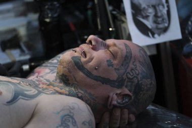 Brüksel, Belçika. 9 Kasım 2019. Uluslararası Brüksel Dövme Kongresi sırasında bir dövme sanatçısı bir kişiye dövme yaptırdı.