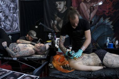 Brüksel, Belçika. 9 Kasım 2019. Uluslararası Brüksel Dövme Kongresi sırasında bir dövme sanatçısı bir kişiye dövme yaptırdı.