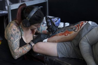 Brüksel, Belçika. 9 Kasım 2019. Uluslararası Brüksel Dövme Kongresi sırasında bir dövme sanatçısı bir kişiye dövme yaptırdı.