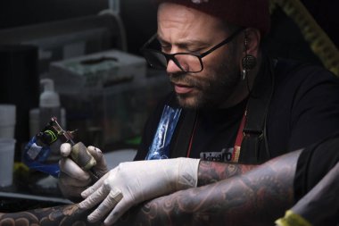 Brüksel, Belçika. 9 Kasım 2019. Uluslararası Brüksel Dövme Kongresi sırasında bir dövme sanatçısı bir kişiye dövme yaptırdı.