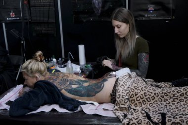 Brüksel, Belçika. 9 Kasım 2019. Uluslararası Brüksel Dövme Kongresi sırasında bir dövme sanatçısı bir kişiye dövme yaptırdı.