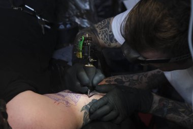 Brüksel, Belçika. 9 Kasım 2019. Uluslararası Brüksel Dövme Kongresi sırasında bir dövme sanatçısı bir kişiye dövme yaptırdı.