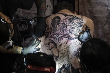 Brüksel, Belçika. 9 Kasım 2019. Uluslararası Brüksel Dövme Kongresi sırasında bir dövme sanatçısı bir kişiye dövme yaptırdı.