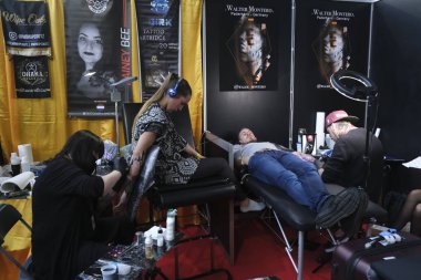 Brüksel, Belçika. 9 Kasım 2019. Uluslararası Brüksel Dövme Kongresi sırasında bir dövme sanatçısı bir kişiye dövme yaptırdı.