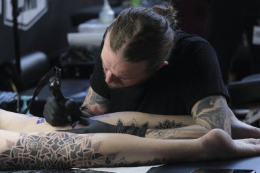 Brüksel, Belçika. 9 Kasım 2019. Uluslararası Brüksel Dövme Kongresi sırasında bir dövme sanatçısı bir kişiye dövme yaptırdı.